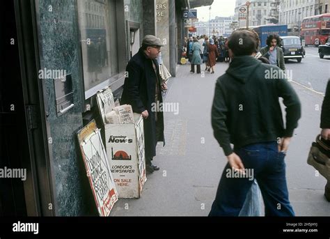 London 1982. A street view of a London street with a newspaper salesman ...