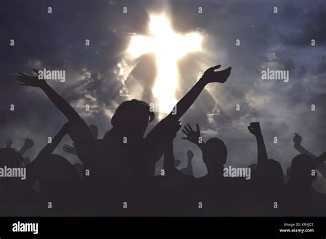 Crowd of christian people praying together to god with dramatic sky background Stock Photo - Alamy