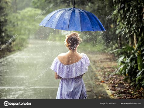 Girl with umbrella under the rain Stock Photo by ©puhimec 169754932