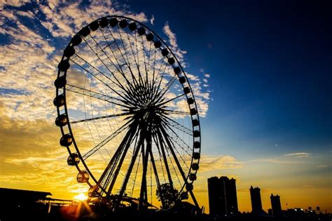 Premium Photo | Ferris wheel in black silhouette at sunset.