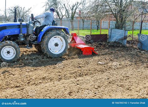 Farmer Plows the Field. Small Tractor with a Plow in the Field ...