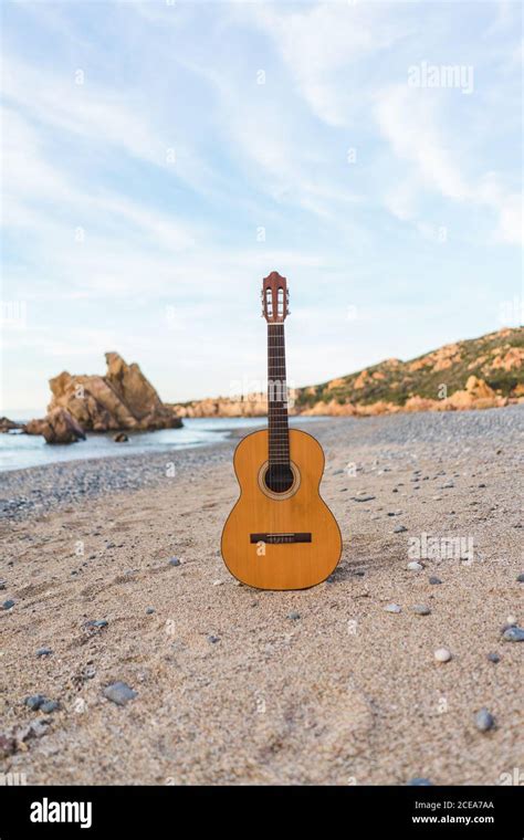 Classic acoustic guitar placed at the ocean on a beach Stock Photo - Alamy