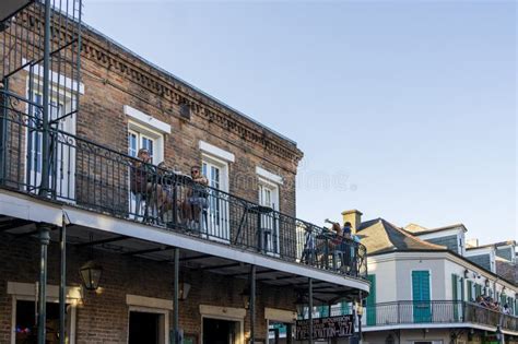 People Standing on a Balcony Having Drinks on Bourbon Street with Restaurants and Bars Along the ...