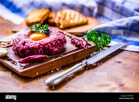 Raw beef .Tasty Steak tartare. Classic steak tartare on wooden board ...