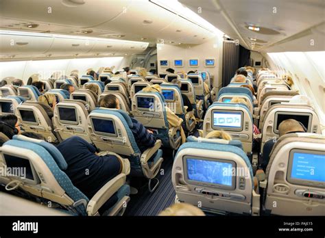 passengers sitting in the economy-class cabin seats of a Singapore Airlines SIA Airbus A380-800 ...