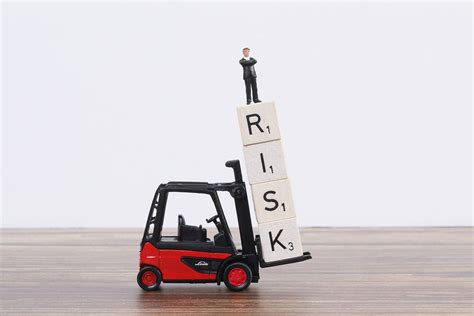 Toy forklift holds wooden blocks with Risk text and businessman - Creative Commons Bilder