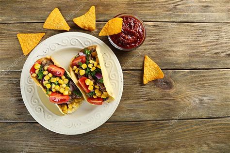 Mexican food Taco in plate on wooden table, top view — Stock Photo © belchonock #74655669