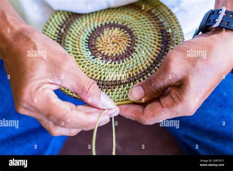 A pinikas artisan working on a basket using local materials at the Kilaha Foundation in Camiguin ...