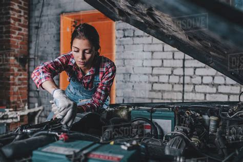 Female mechanic repairing car engine at garage - Stock Photo - Dissolve