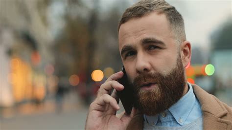 Free stock video - Close-up view of caucasian businessman with a beard talking on the phone in ...