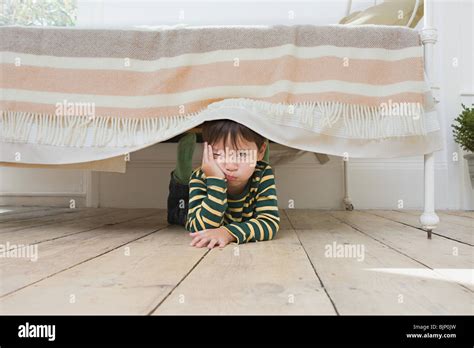 Boy hiding under a bed Stock Photo - Alamy