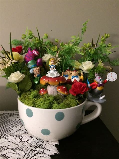 a cup filled with lots of plants and small figurines