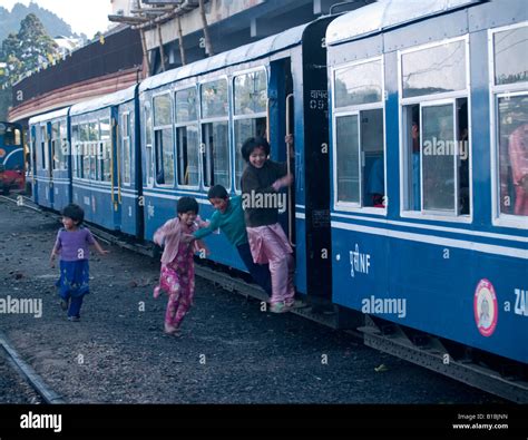 kids jumping on the Darjeeling toy train as it leaves the station Stock ...