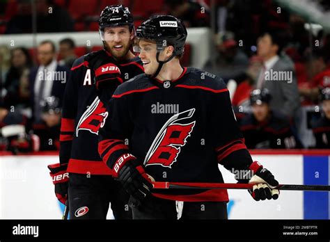 Carolina Hurricanes' Max Domi (13) jokes with teammate Jaccob Slavin ...