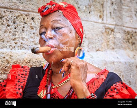 Cuban woman smoking cigar, in traditional dress, looks at camera, portrait, Havana, Cuba Stock ...