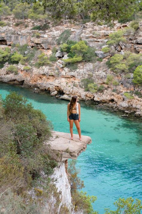 Woman Standing on a Ledge Over the Sea in Beautiful Soft Sunlight, Cala ...