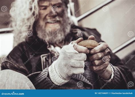 Caucasian Homeless Man Happy To Get a Bun and Holding it with Both ...