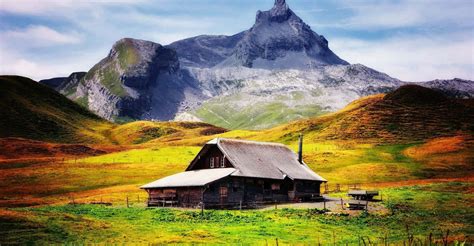 Download Cabin Overlooking A Snowy Mountain Wallpaper | Wallpapers.com