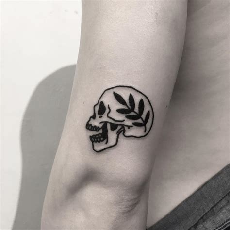 Small skull and branch tattoo - Tattoogrid.net