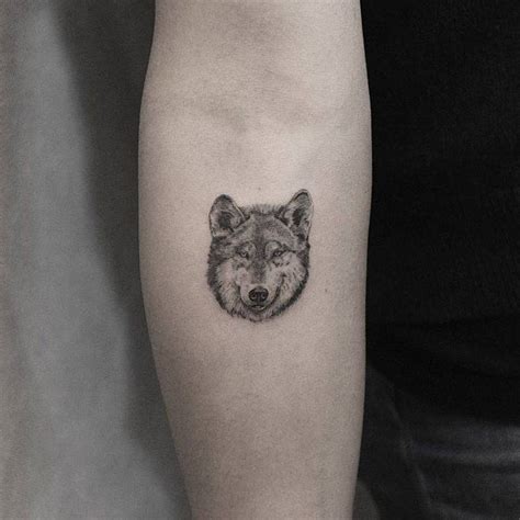 Single needle wolf head tattoo on the inner forearm.