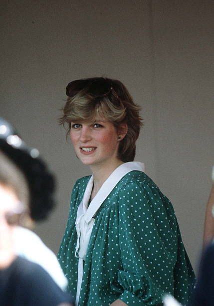 a woman in a green and white polka dot dress smiles while standing next to other people