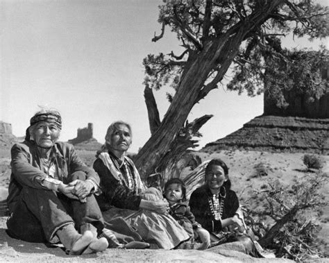 Navajo family sitting on ground by tree. Monument Valley, 1960's