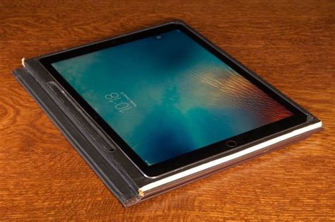 an ipad is sitting on top of a leather case with its cover open and ...