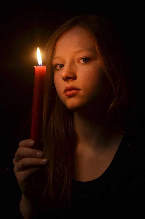 a woman holding a lit candle in her hand