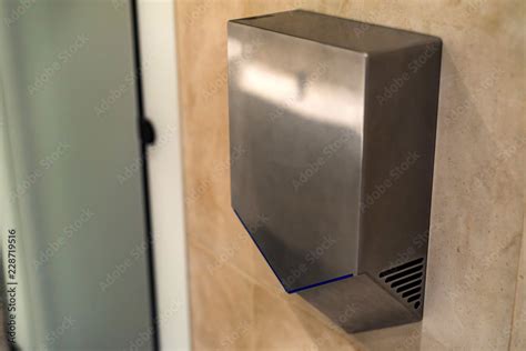 Hand dryer on wall in public toilet, closeup Stock Photo | Adobe Stock