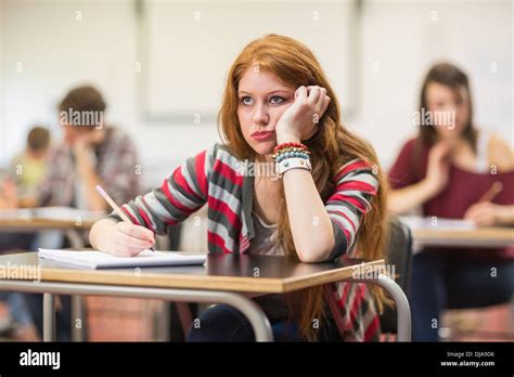 Bored female student with others writing notes in classroom Stock Photo - Alamy