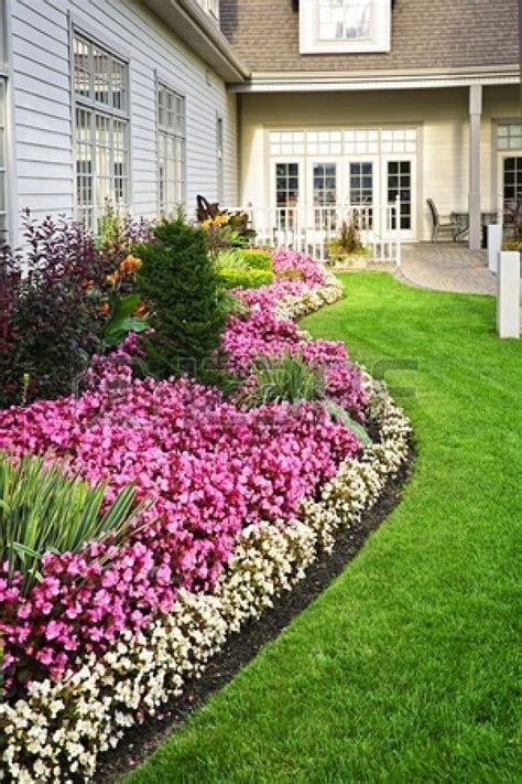 Flowerbed of colorful flowers against wall with windows | Garden landscape design, Flower ...