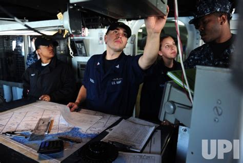 Photo: Crew members work on the bridge of the USS Bataan ...