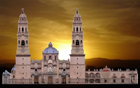 the sun is setting in front of a large building with two towers on each ...