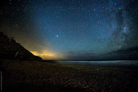 "Stars Over A Beach With Lights Afar" by Stocksy Contributor "Joaquim Bel" - Stocksy