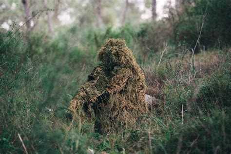 A ghillie suited sniper of the Israeli Defense Force demonstrates camouflage techniques at the ...