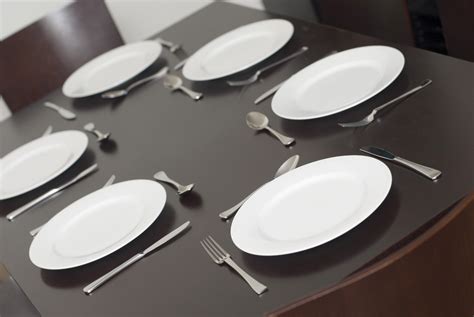 Black dining table set with clean white plates - Free Stock Image