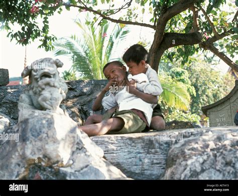 Two young Thai boys playing in a grounds of a Bangkok temple Stock ...