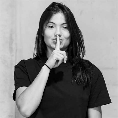 black and white photograph of a woman making a hush sign with her ...