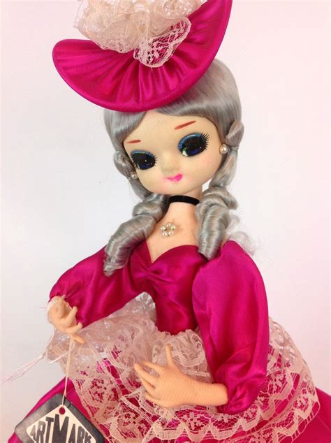 a doll wearing a pink dress and hat