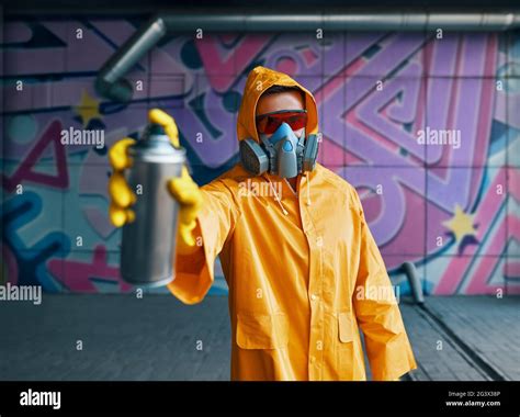 Graffiti artist pointing spray paint can to camera Stock Photo - Alamy