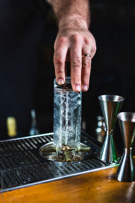 "Unrecognizable Bartender Cleaning Glasses With Splashing Water" by Stocksy Contributor "Giorgio ...