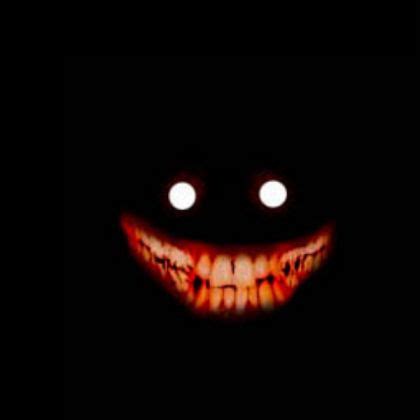 an evil looking face with glowing eyes in the dark