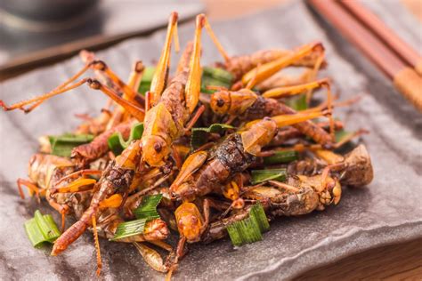 a pile of fried food sitting on top of a wooden table next to chopsticks