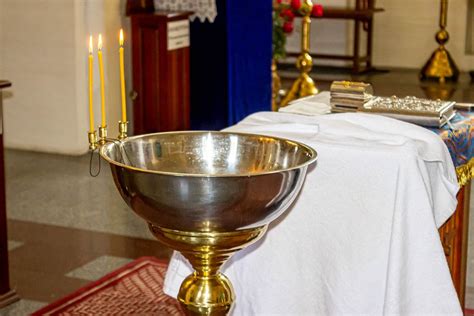 The concept of child baptism in the Christian Church. A bowl of water ...