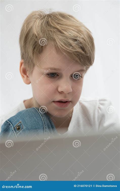 The Blond Child Looks Attentively at the Computer or Laptop Screen. Close-up Portrait Stock ...