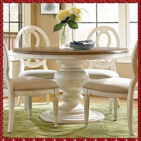 a dining room table with chairs and a vase filled with flowers on top of it