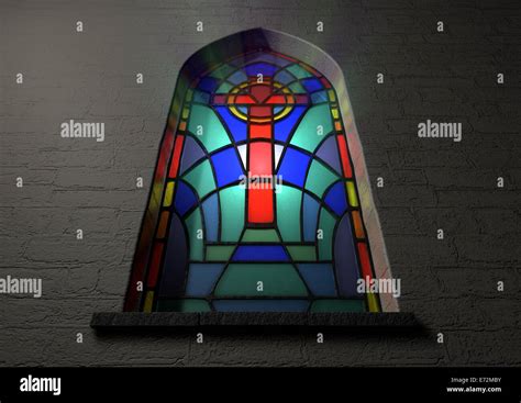 A colorful patterned stain glass window with the shape of a crucifix designed into it ...