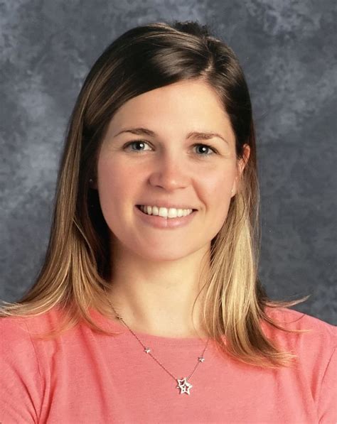 a woman in a pink shirt smiling at the camera