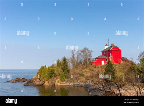 Red lighthouse on Lake Superior shore. The historic Marquette Harbor Lighthouse in Marquette ...