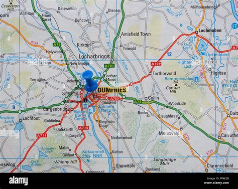 Road map of the Dumfries area of Scotland, showing the surrounding roads and with a map pin in ...